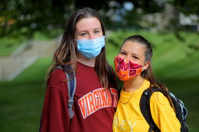 Two college students standing together in masks 